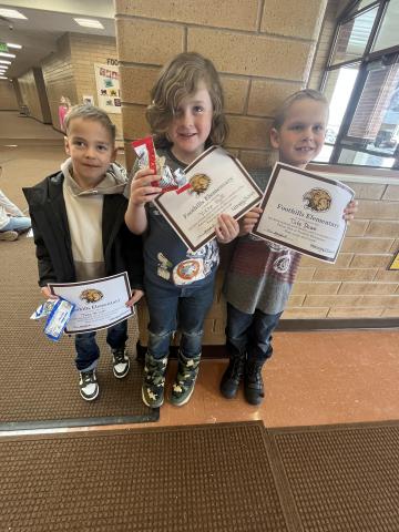 Students showing their certificate and cookies