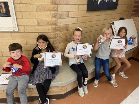 Students holding certificates and cookies