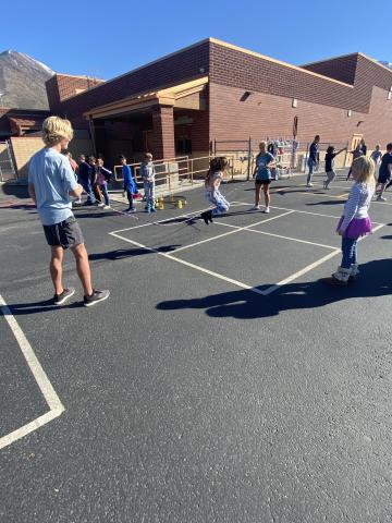 High School athletes playing jumprope with students