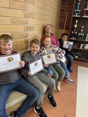 Students showing their certificates while eating cookies