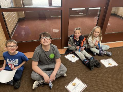 Students sitting on carpet eating cookies