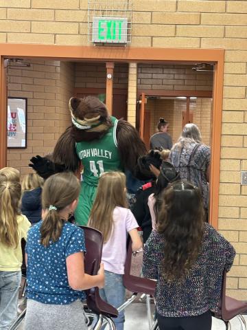 Willie Wolverine giving high 5s to students.